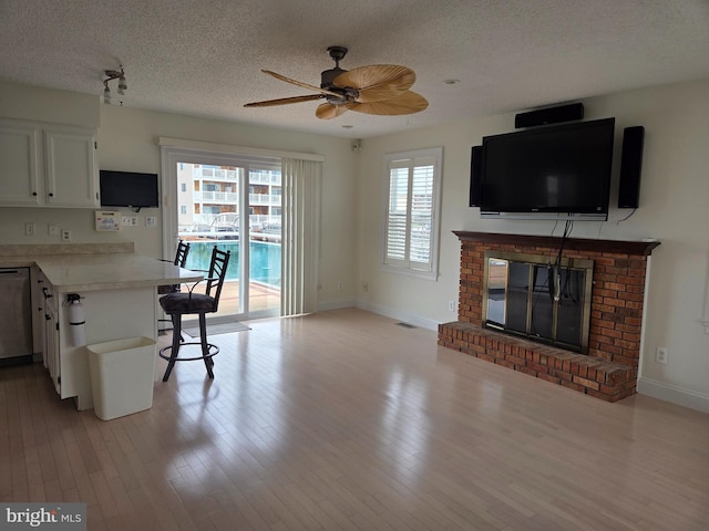 156 Captains Quarters Rd, Ocean City, MD 21842 - kitchen with dishwasher, a textured ceiling, light countertops, ceiling fan, and a fireplace