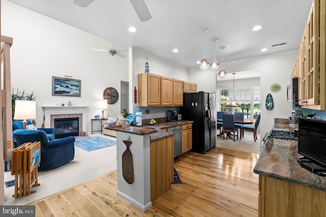128 Rowan Ct, Manahawkin, NJ 08050 - kitchen with black fridge with ice dispenser, stainless steel dishwasher, ceiling fan, light wood finished floors, and a peninsula