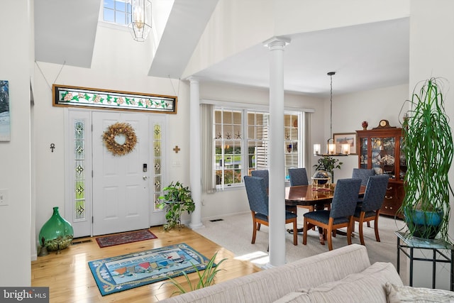 128 Rowan Ct, Manahawkin, NJ 08050 - entryway featuring decorative columns, wood finished floors, a high ceiling, and a chandelier