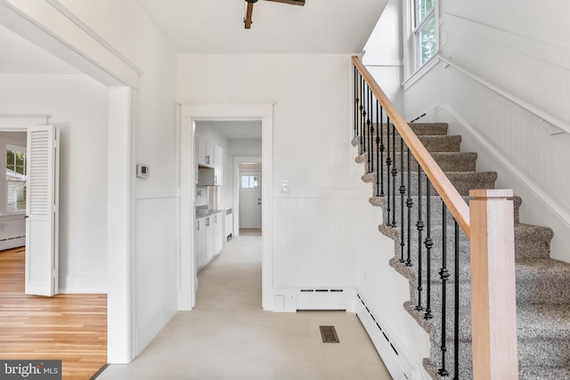 1029 Pennsylvania Ave, Hagerstown, MD 21742 - staircase featuring a wainscoted wall, a baseboard heating unit, and a ceiling fan