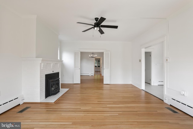 1029 Pennsylvania Ave, Hagerstown, MD 21742 - unfurnished living room with a ceiling fan, baseboard heating, light wood-style floors, a brick fireplace, and a baseboard radiator