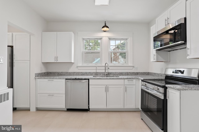 1029 Pennsylvania Ave, Hagerstown, MD 21742 - kitchen with stainless steel appliances, white cabinets, radiator heating unit, and light stone counters