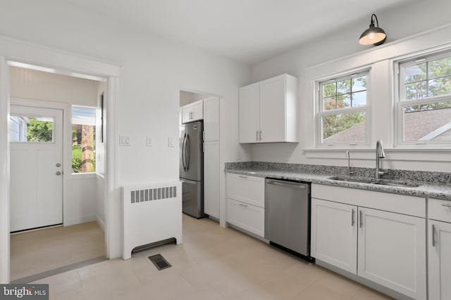 1029 Pennsylvania Ave, Hagerstown, MD 21742 - kitchen with stainless steel appliances, radiator heating unit, healthy amount of natural light, and light stone countertops