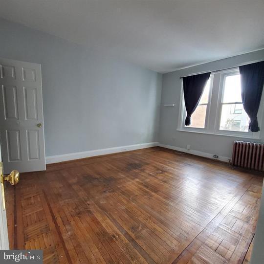 1212 Park Rd NW, Washington, DC 20010 - unfurnished room featuring radiator and wood finished floors