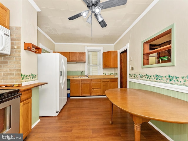 526 W Potomac St, Brunswick, MD 21716 - kitchen with white appliances, crown molding, light wood finished floors, ceiling fan, and brown cabinetry