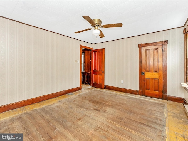 526 W Potomac St, Brunswick, MD 21716 - spare room featuring hardwood / wood-style floors, ceiling fan, wallpapered walls, and crown molding