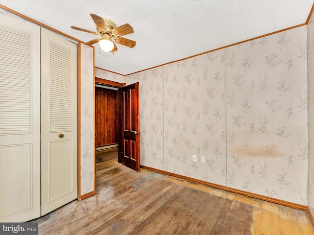 526 W Potomac St, Brunswick, MD 21716 - unfurnished bedroom with hardwood / wood-style floors, a closet, ornamental molding, baseboard heating, and a ceiling fan
