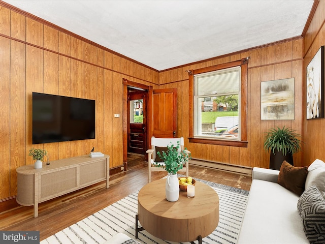 526 W Potomac St, Brunswick, MD 21716 - living area with a baseboard radiator, wooden walls, ornamental molding, and wood-type flooring