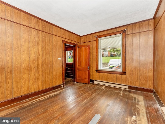 526 W Potomac St, Brunswick, MD 21716 - empty room with a baseboard radiator, wood-type flooring, wooden walls, and crown molding