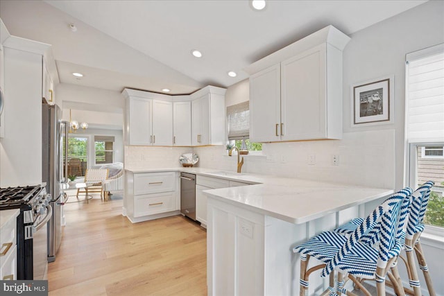 931 Oyster Bay Pl, Solomons, MD 20688 - kitchen featuring stainless steel appliances, a peninsula, white cabinets, tasteful backsplash, and recessed lighting