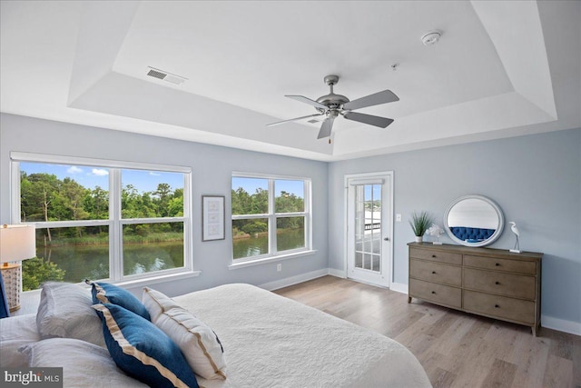 931 Oyster Bay Pl, Solomons, MD 20688 - bedroom featuring a raised ceiling, access to outside, wood finished floors, and a water view