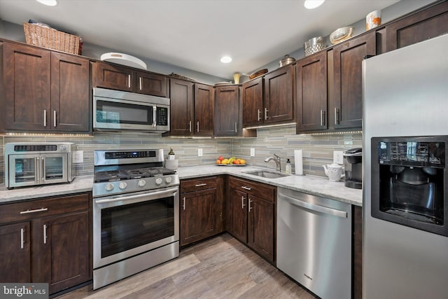 3508 Waltham Ct, Yardley, PA 19067 - kitchen with stainless steel appliances, light wood-style floors, dark brown cabinets, backsplash, and light stone countertops