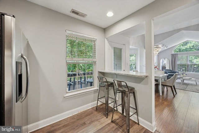 3508 Waltham Ct, Yardley, PA 19067 - kitchen featuring stainless steel refrigerator with ice dispenser, wood finished floors, a chandelier, a breakfast bar area, and light stone counters