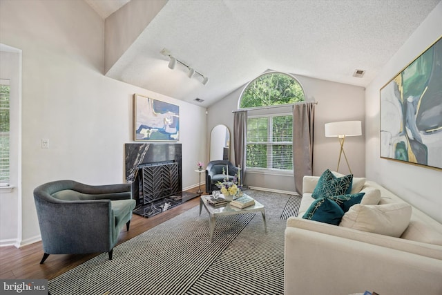 3508 Waltham Ct, Yardley, PA 19067 - living area featuring wood finished floors, lofted ceiling, a premium fireplace, track lighting, and a textured ceiling