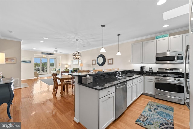 38336 Ocean Vista Dr Unit 1098, Selbyville, DE 19975 - kitchen with stainless steel appliances, a peninsula, open floor plan, ornamental molding, and light wood-type flooring