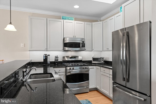 38336 Ocean Vista Dr Unit 1098, Selbyville, DE 19975 - kitchen with appliances with stainless steel finishes, crown molding, dark stone countertops, pendant lighting, and decorative backsplash