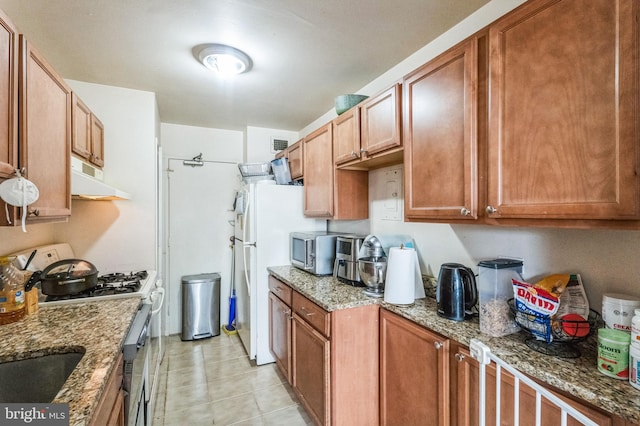 1900 Lyttonsville Rd Unit 818, Silver Spring, MD 20910 - kitchen featuring gas range oven, stainless steel microwave, ventilation hood, light stone countertops, and freestanding refrigerator