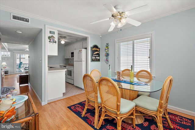 11603 Seaward Rd Unit 6, Ocean City, MD 21842 - dining space with ceiling fan, light wood-style flooring, crown molding, and a textured ceiling
