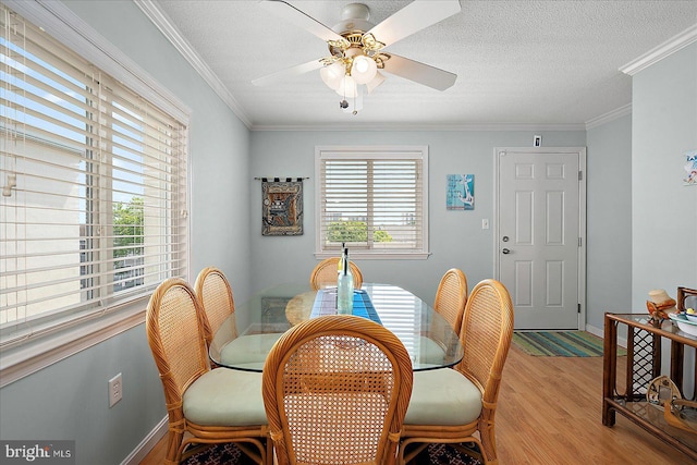 11603 Seaward Rd Unit 6, Ocean City, MD 21842 - dining space with light wood-type flooring, ceiling fan, crown molding, and a textured ceiling