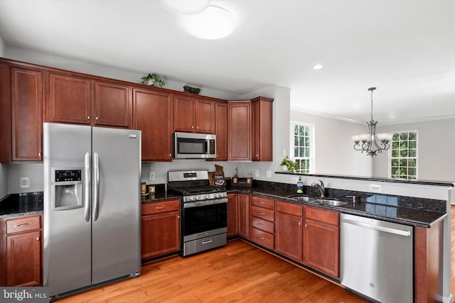 42806 Longworth Ter, Chantilly, VA 20152 - kitchen featuring appliances with stainless steel finishes, a peninsula, light wood finished floors, a chandelier, and dark stone counters