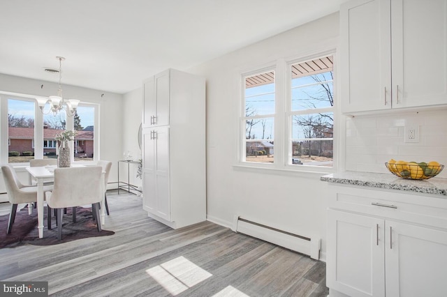 5917 Linthicum Ln, Linthicum Heights, MD 21090 - dining space featuring baseboard heating, a chandelier, and light wood-style flooring