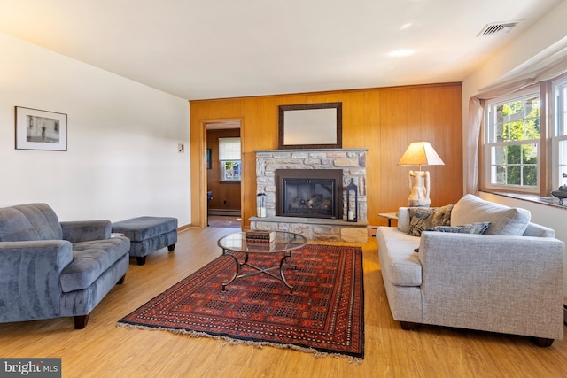 1540 Davidson Rd, Abington, PA 19001 - living room with a stone fireplace, wood finished floors, wooden walls, and baseboard heating