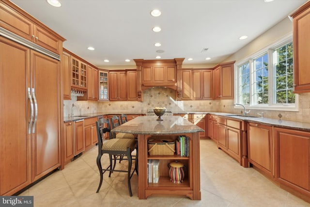 2573 Muirfield Way, Lansdale, PA 19446 - kitchen with paneled built in refrigerator, open shelves, dark stone counters, brown cabinetry, and tasteful backsplash
