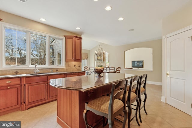 2573 Muirfield Way, Lansdale, PA 19446 - kitchen with a breakfast bar area, light tile patterned floors, dark stone countertops, a chandelier, and a kitchen island