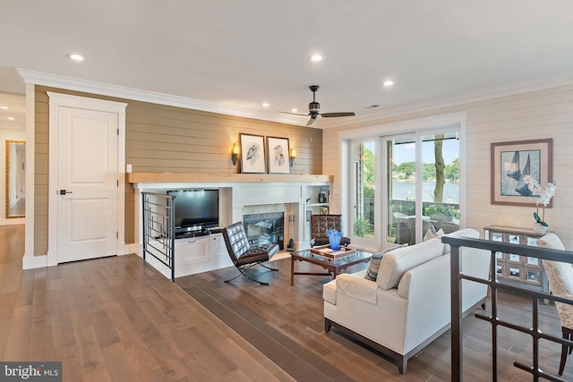 16 Spa Creek Lndg, Annapolis, MD 21403 - living room featuring ornamental molding, a glass covered fireplace, ceiling fan, wood walls, and dark wood-type flooring