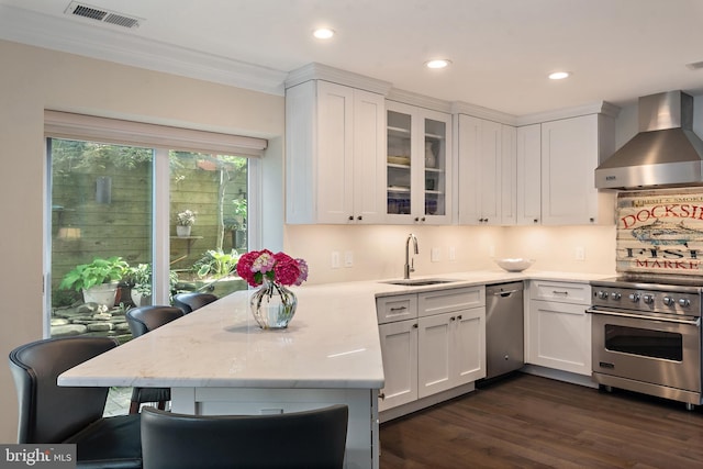 16 Spa Creek Lndg, Annapolis, MD 21403 - kitchen with wall chimney range hood, appliances with stainless steel finishes, white cabinets, a peninsula, and recessed lighting