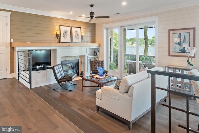 16 Spa Creek Lndg, Annapolis, MD 21403 - living area with ornamental molding, a ceiling fan, wooden walls, dark wood-type flooring, and a fireplace with flush hearth