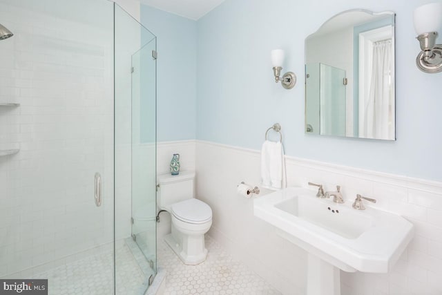 673 Ardmore Ave, Ardmore, PA 19003 - bathroom featuring tile walls, a stall shower, a wainscoted wall, and tile patterned floors