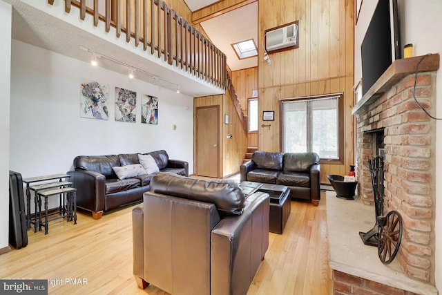 138 Banbury Dr, Bushkill, PA 18324 - living room featuring wood walls, rail lighting, light wood-type flooring, a wall mounted air conditioner, and a high ceiling