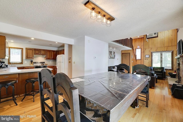 138 Banbury Dr, Bushkill, PA 18324 - dining area with a textured ceiling, light wood-style floors, and wood walls