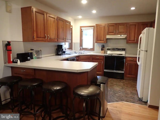 138 Banbury Dr, Bushkill, PA 18324 - kitchen with electric range, under cabinet range hood, freestanding refrigerator, a peninsula, and light countertops