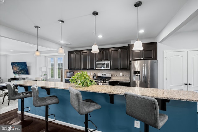 7444 Saint Margarets Blvd Unit A, Hanover, MD 21076 - kitchen with appliances with stainless steel finishes, backsplash, dark wood-style floors, light stone countertops, and a breakfast bar area