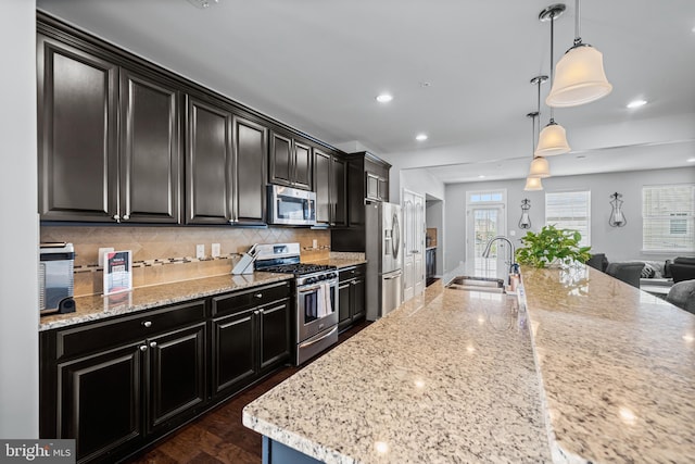 7444 Saint Margarets Blvd Unit A, Hanover, MD 21076 - kitchen featuring stainless steel appliances, open floor plan, decorative backsplash, dark cabinetry, and light stone countertops