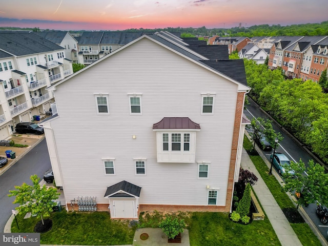 7444 Saint Margarets Blvd Unit A, Hanover, MD 21076 - back of property at dusk with a residential view, a standing seam roof, a metal roof, and brick siding