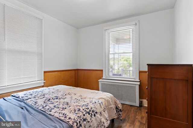 229 E Canal St, Hershey, PA 17033 - bedroom featuring radiator heating unit, a wainscoted wall, wood finished floors, and wooden walls