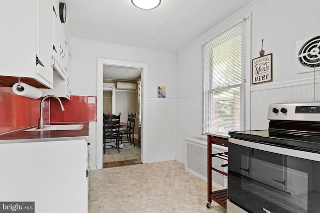 229 E Canal St, Hershey, PA 17033 - kitchen featuring stainless steel range with electric stovetop, wainscoting, white cabinetry, and ornamental molding