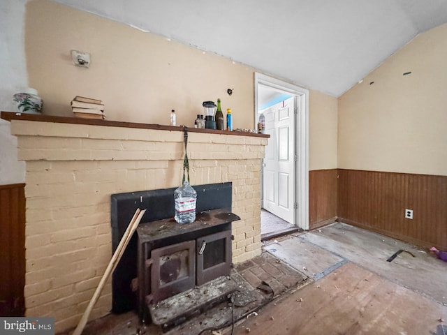 4725 Idlewilde Rd, Shady Side, MD 20764 - unfurnished living room featuring wainscoting, a wood stove, lofted ceiling, and wood walls
