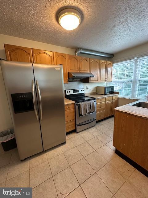710 Wildell Rd Unit 108, Drexel Hill, PA 19026 - kitchen featuring stainless steel appliances, under cabinet range hood, a textured ceiling, light countertops, and light tile patterned floors