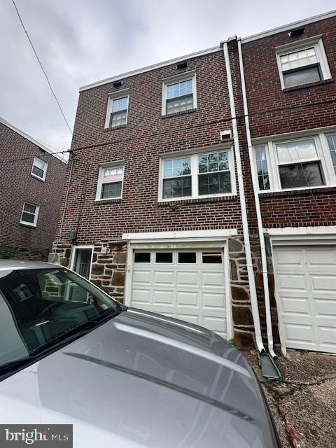 710 Wildell Rd Unit 108, Drexel Hill, PA 19026 - view of front of home featuring an attached garage, brick siding, and driveway