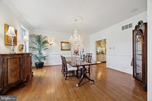 845 Colony Ct, Bryn Mawr, PA 19010 - dining room with a chandelier, ornamental molding, wood finished floors, a wainscoted wall, and a decorative wall