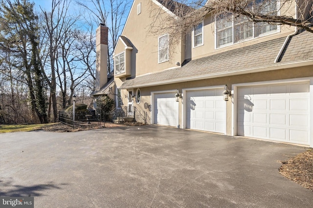 845 Colony Ct, Bryn Mawr, PA 19010 - view of side of property with driveway, stucco siding, a chimney, and a garage