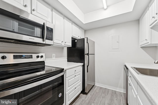 18330 Streamside Dr Unit 303, Gaithersburg, MD 20879 - kitchen with appliances with stainless steel finishes, light wood-style floors, electric panel, white cabinetry, and light countertops