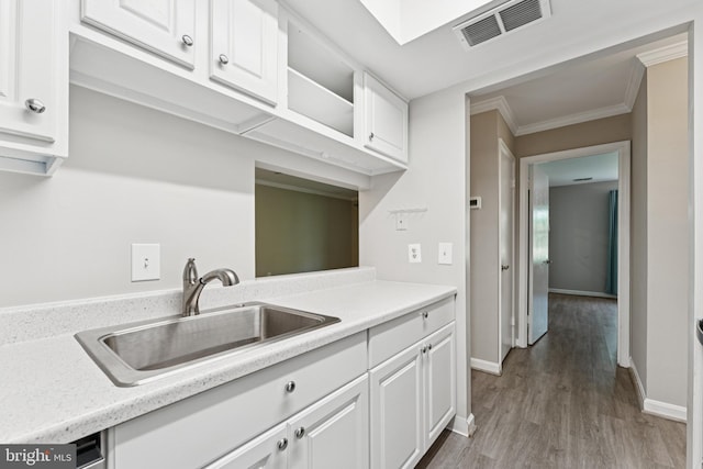 18330 Streamside Dr Unit 303, Gaithersburg, MD 20879 - kitchen with white cabinetry, light countertops, wood finished floors, and ornamental molding