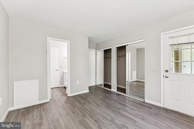 18330 Streamside Dr Unit 303, Gaithersburg, MD 20879 - unfurnished bedroom featuring wood finished floors and two closets