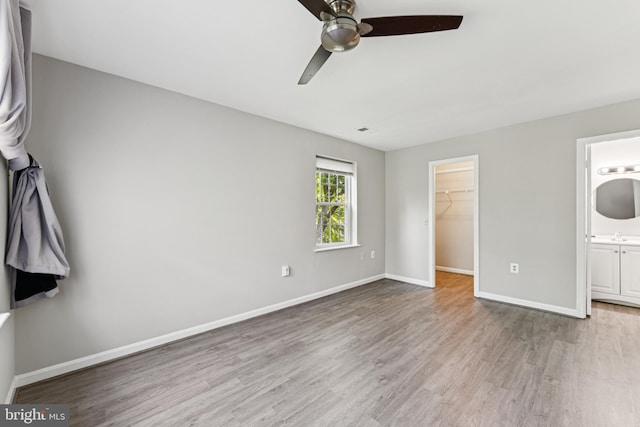 18330 Streamside Dr Unit 303, Gaithersburg, MD 20879 - unfurnished bedroom with wood finished floors, a walk in closet, a ceiling fan, connected bathroom, and a closet