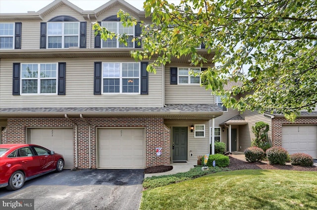 277 Thrush Dr, Hummelstown, PA 17036 - townhome / multi-family property with driveway, brick siding, a garage, and a front yard